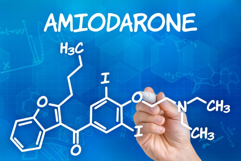 Hand with pen drawing the chemical formula of Amiodarone | Treatment ...